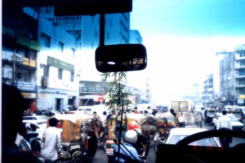 孟加拉城市街道上交通秩序很混乱，这是在达卡拍的一张照片．大量印度产的马自达冒着青烟横行直撞，自行车，行人挤成一团，有时还有水牛在街道上乱窜．从一个侧面反映出这个国家的贫穷落后面貌．